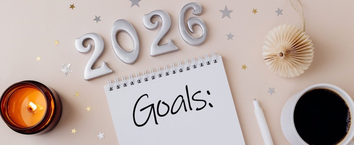 2026 New Year Goals with burning candle, Christmas decorations and cup of coffee. Directly above. Flat lay