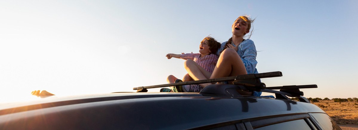 Two people driving in a convertible