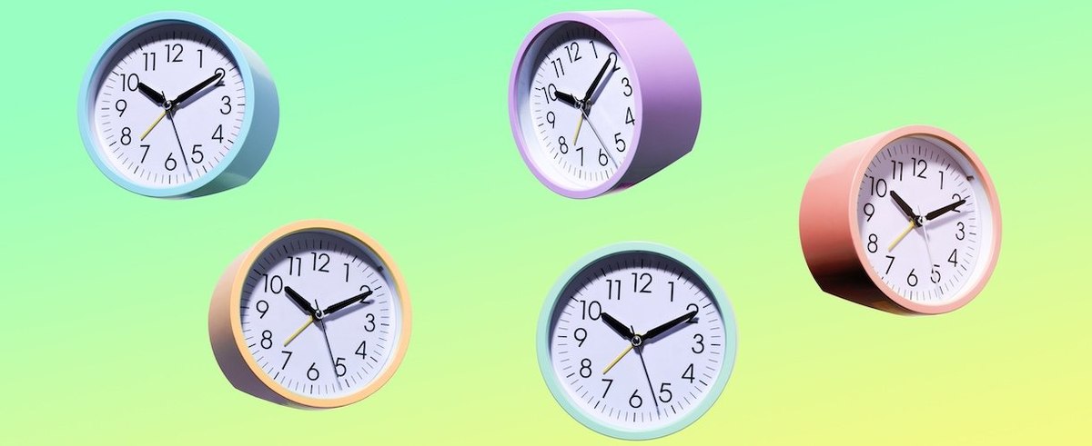 Multi pastel colored clocks in mid air on gradated yellow and green background
