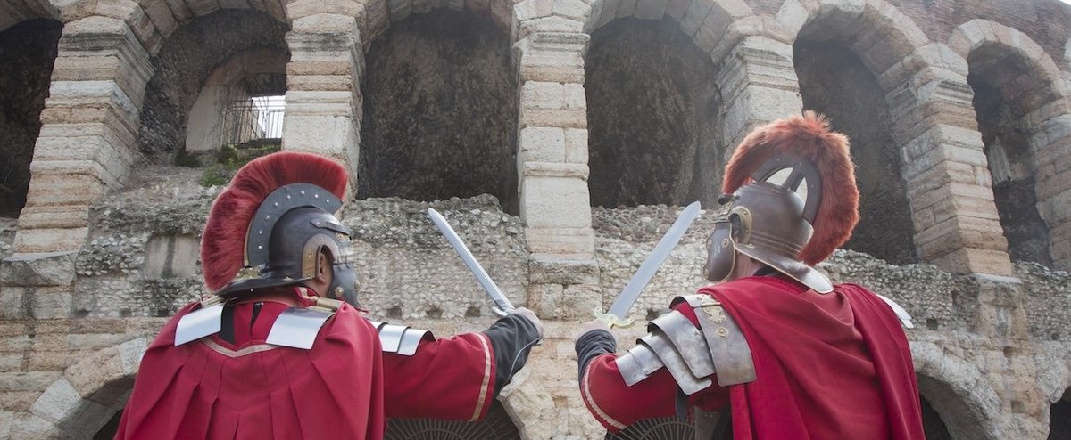 Two people in Roman Legion costumes posing at the Verona Coliseum