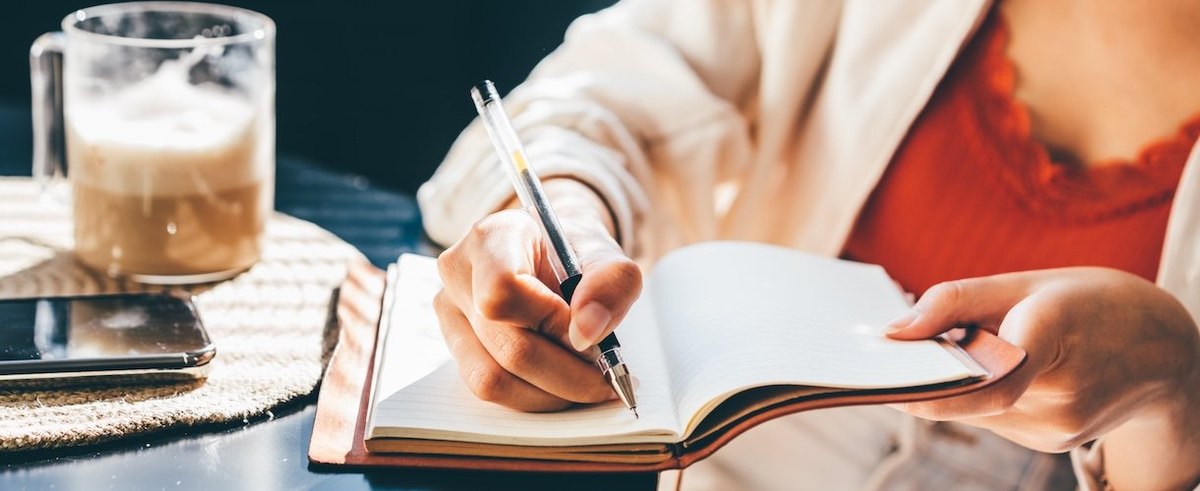 Woman Writing in her Notebook, Making a To-do List.