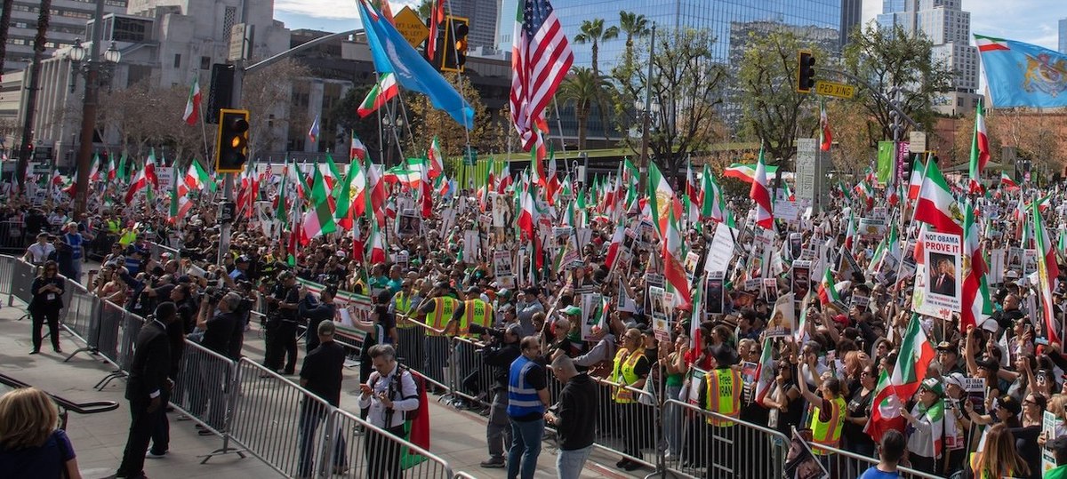 LOS ANGELES, CALIFORNIA - JANUARY 18: Members of the Iranian community and supporters hold signs and pre-regime Iranian flags during a "Solidarity with the People of Iran" event in front of City Hall in Downtown on January 18, 2026 in Los Angeles, California. Thousands of demonstrators gathered in Los Angeles to protest against the government crackdown in Iran. (Photo by Apu Gomes/Getty Images)