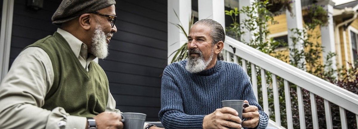 Senior men having coffee in front of suburban home