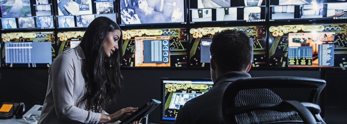 Security guards watching monitors in control room - stock photo